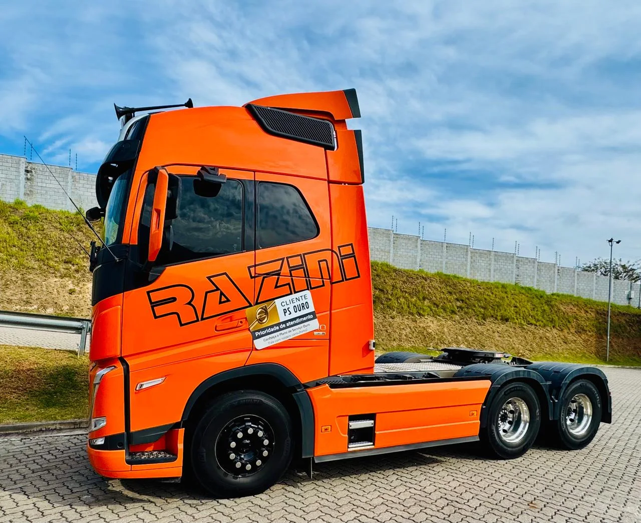 Volvo FH laranja da Razini Transportes visto de lado